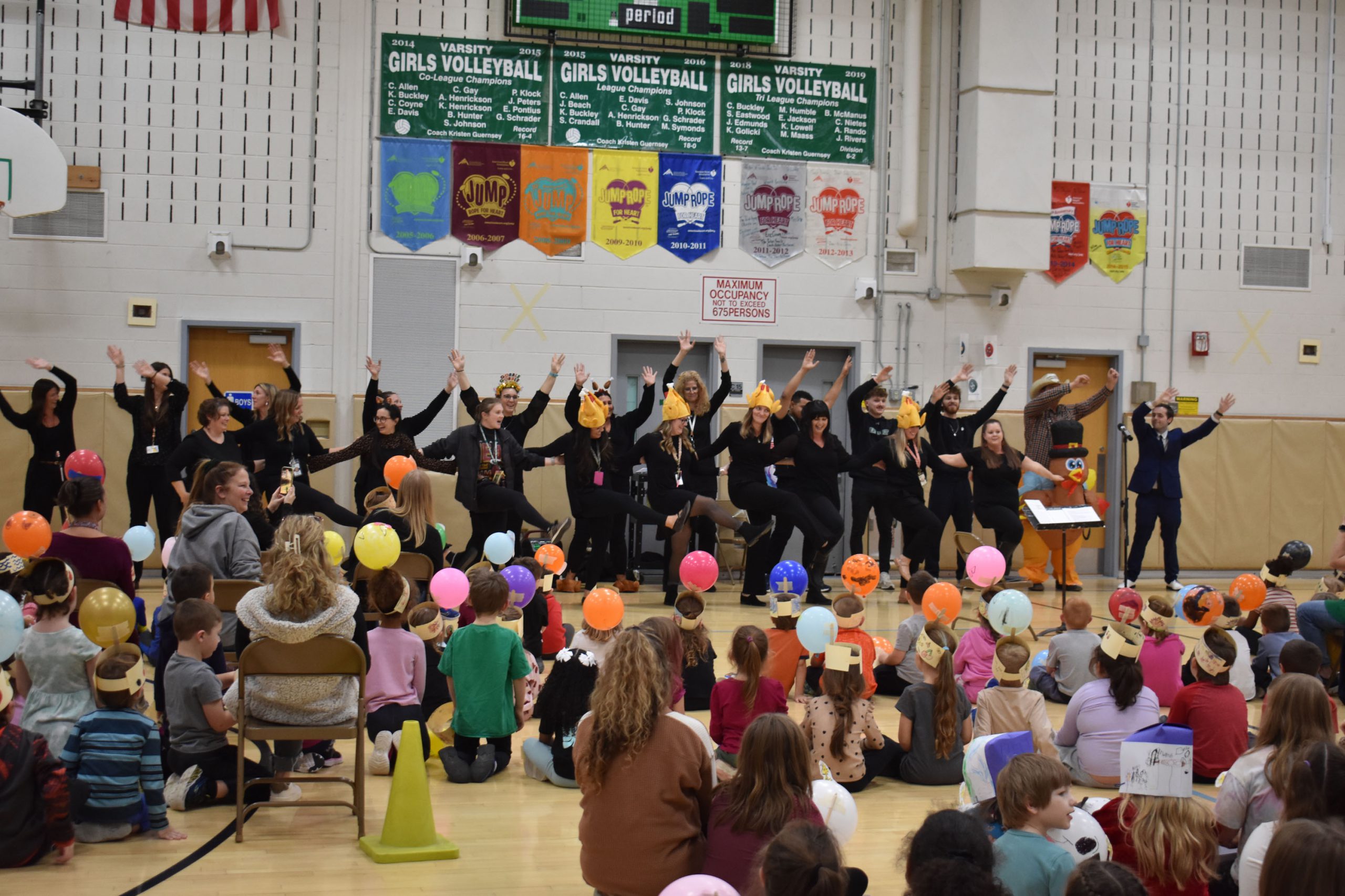 Teachers doing a kick-line at assembly