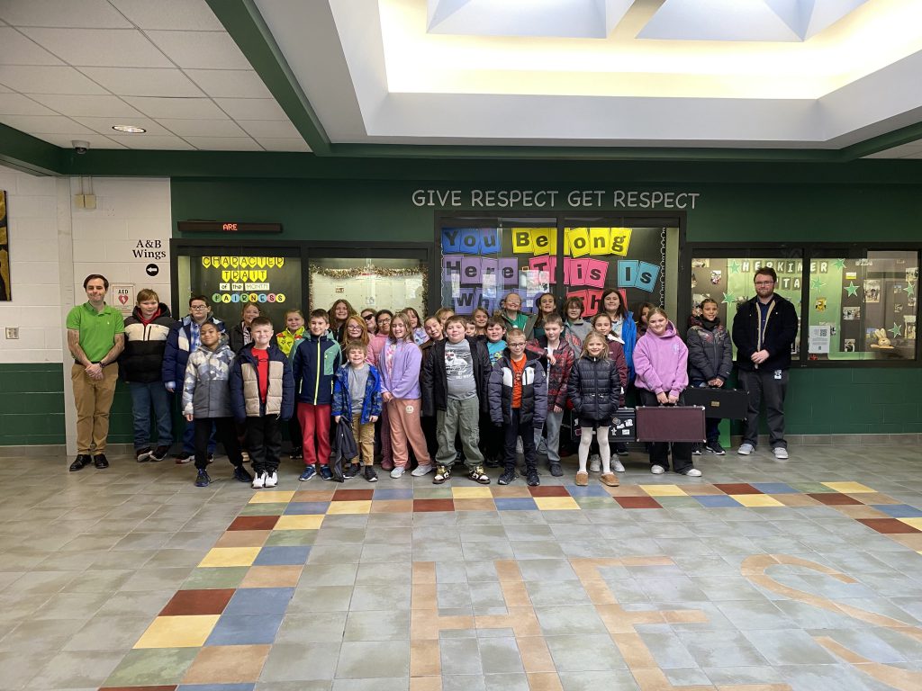 Elementary music students and teachers posing in school lobby