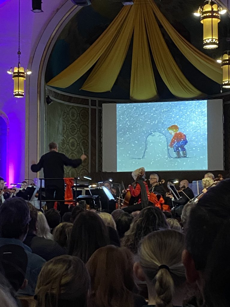 Elementary music students watching orchestra performance