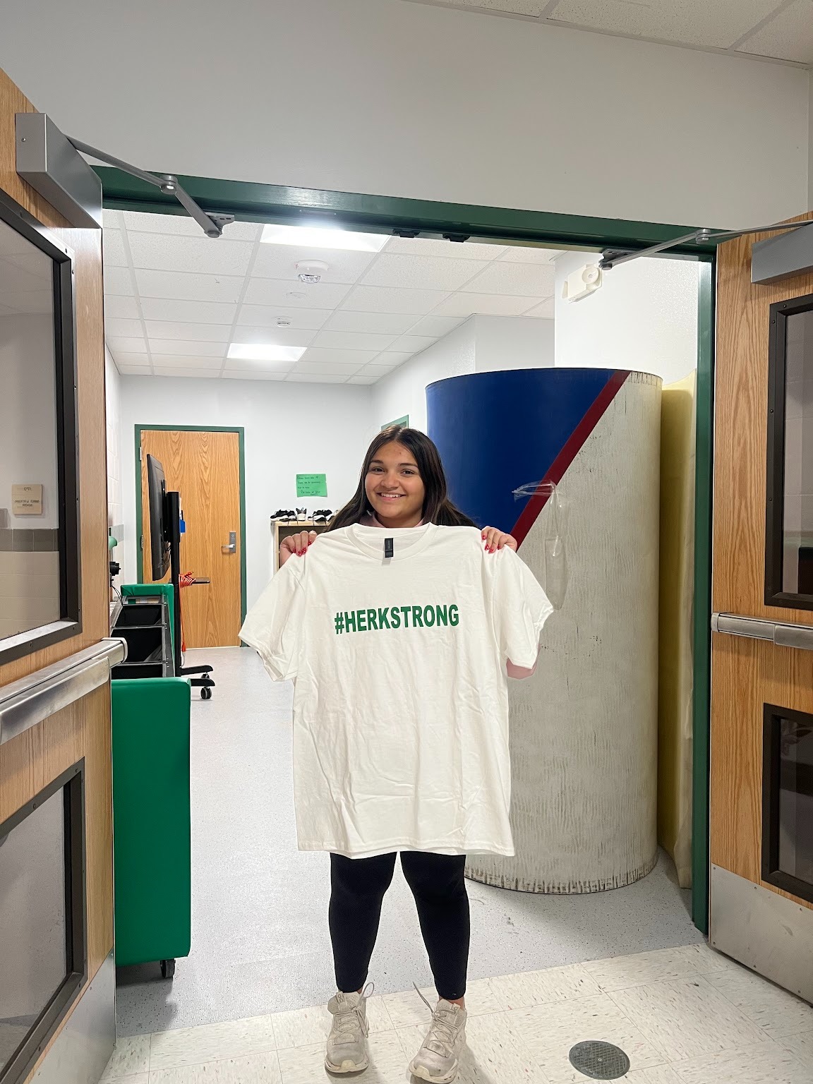 Maya Saugh holding a #HerkStrong shirt