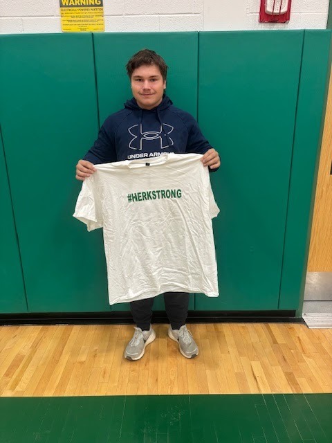 Ross Richard holding a #HerkStrong shirt