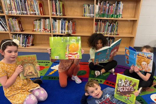 Students reading books on library floor