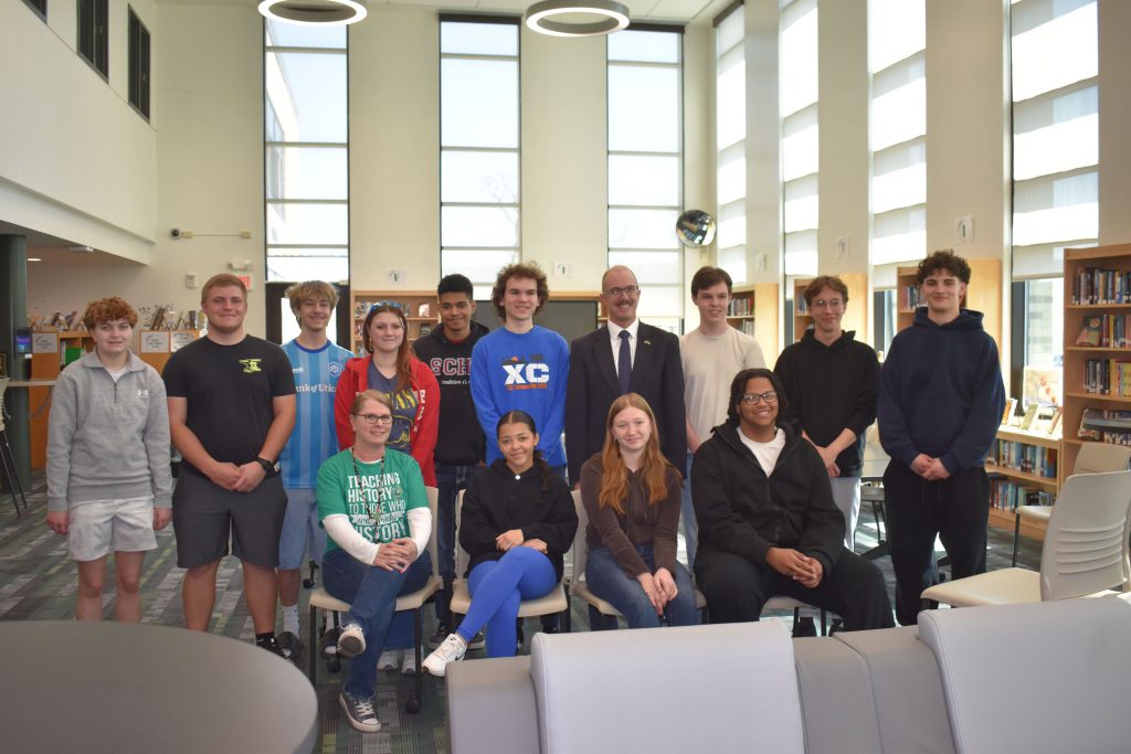 Senator posing with civics class in library