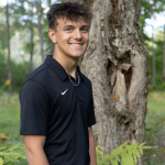 Cole Bolen standing outside by a tree