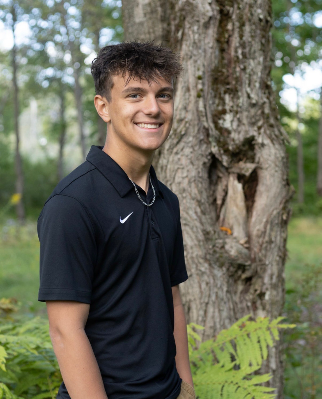 Cole Bolen standing outside by a tree