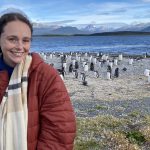 Chanel Meyer in front of many penguins and water