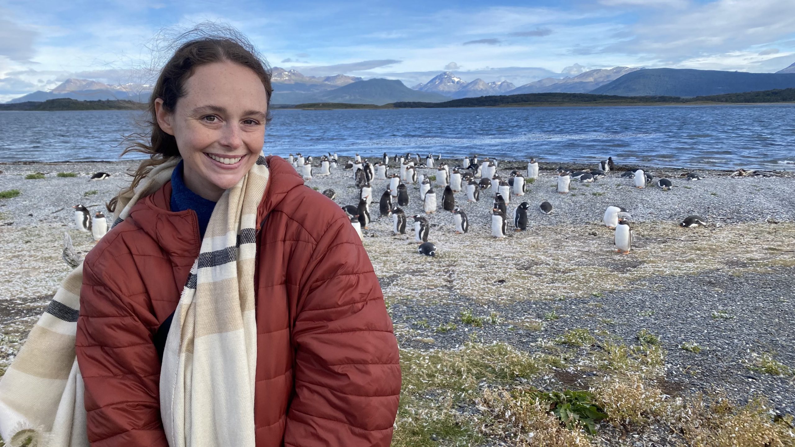 Chanel Meyer in front of many penguins and water