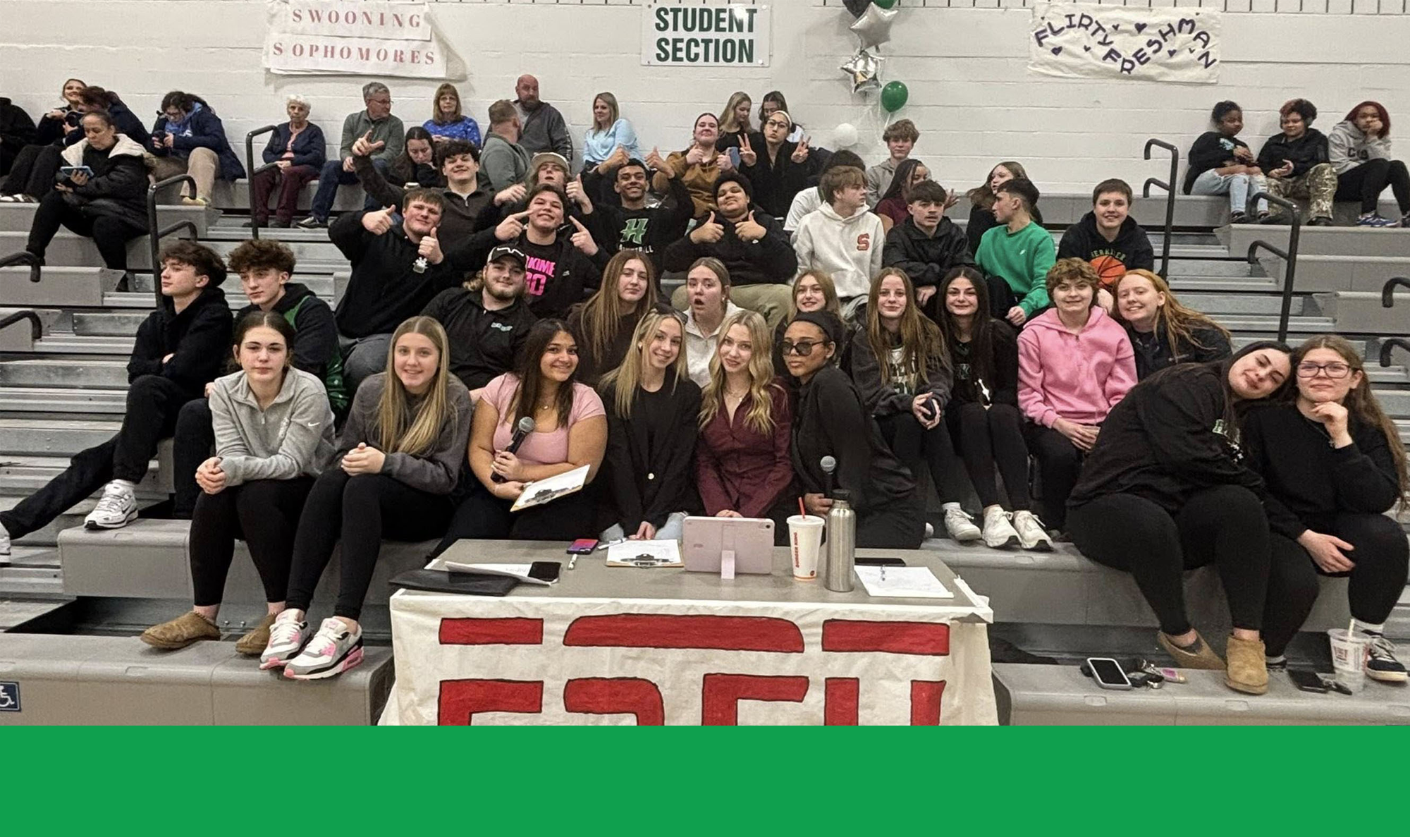Students in bleachers by ESPN sign at basketball game