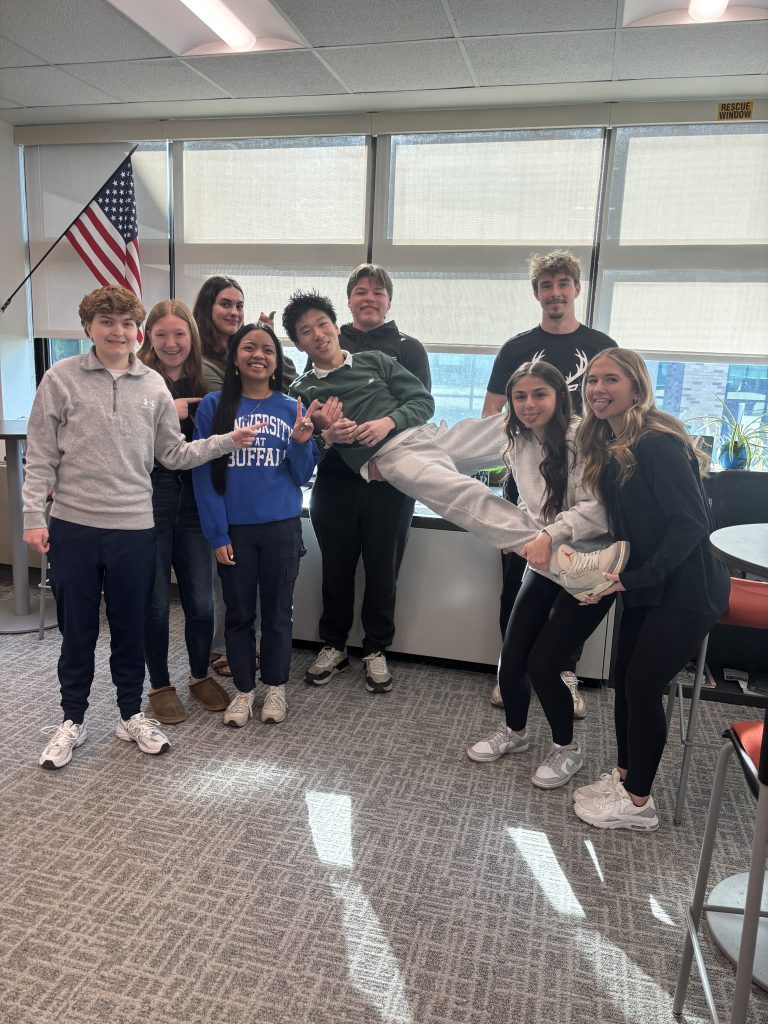 Nine students from the Herkimer CSD top 10 making silly faces and holding one of the students up in the air