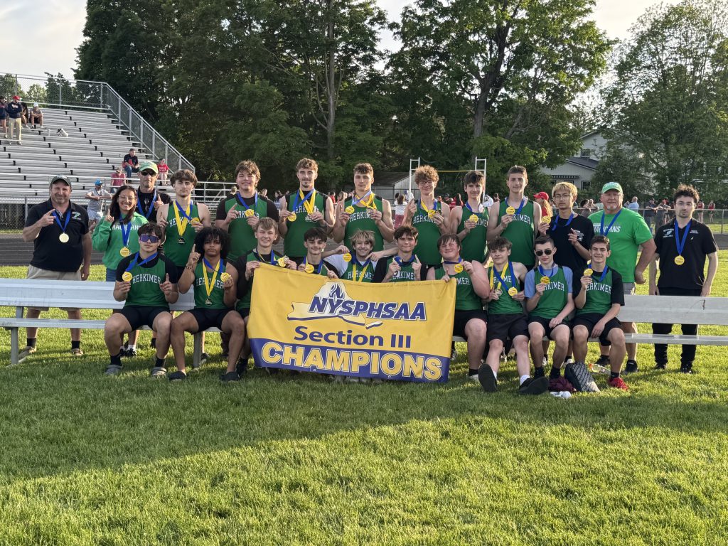 Boys track and field team with sectional championship banner
