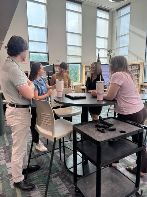 New teachers talking at New Teacher Orientation in Middle-High School Library Media Center