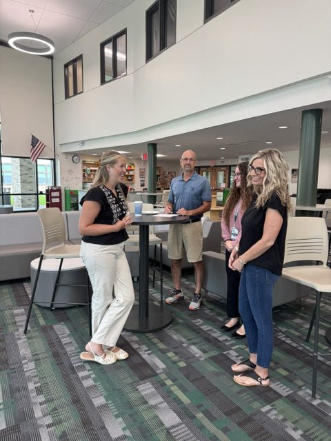 New teachers talking at New Teacher Orientation in Middle-High School Library Media Center