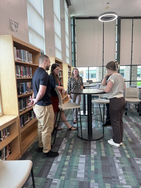 New teachers talking at New Teacher Orientation in Middle-High School Library Media Center