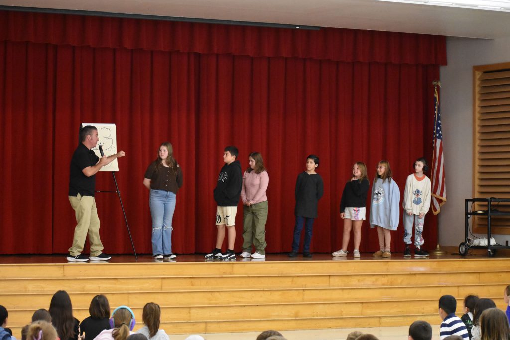 Cartoonist Duane Abel and seven students on stage