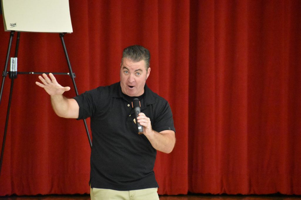 Cartoonist Duane Abel speaking on stage