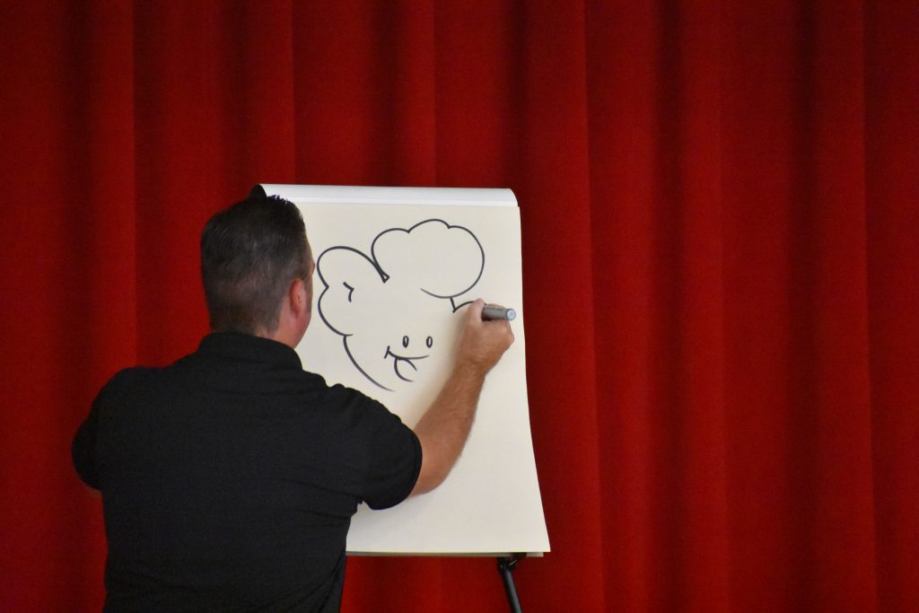 Cartoonist Duane Abel drawing on stage
