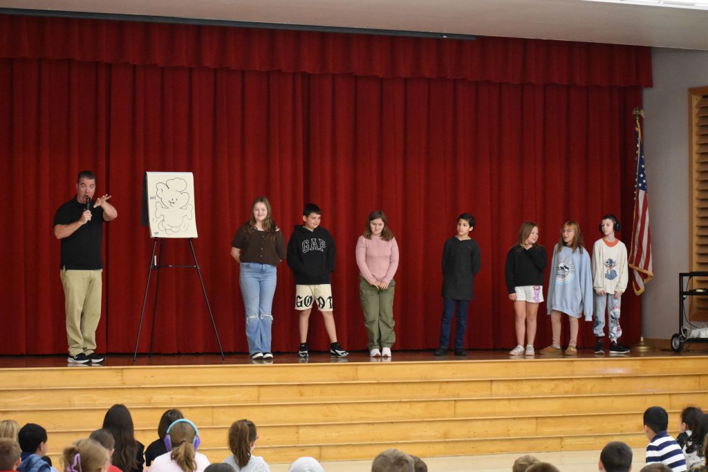 Cartoonist Duane Abel and seven students on stage