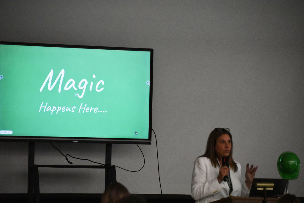 Herkimer Superintendent Kathleen Carney presenting at podium with "Magic happens here" on screen behind her