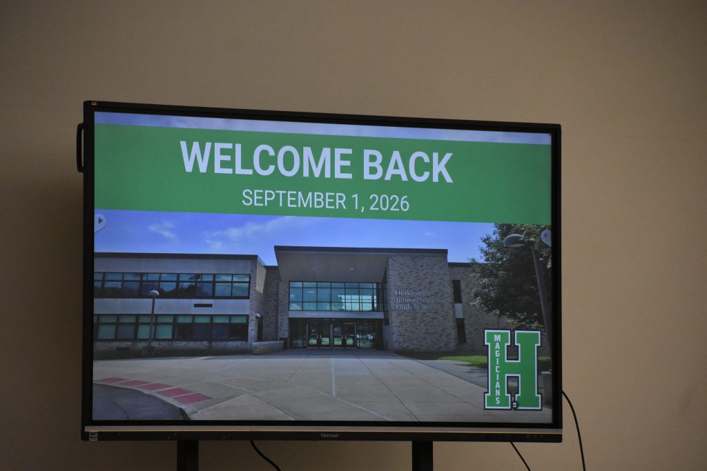 Welcome back slide from presentation is displayed on a large monitor