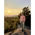 Anna Shelley outside in front of scenery of trees and the sky