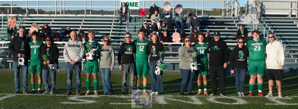 Boys varsity soccer seniors and family in front of stands