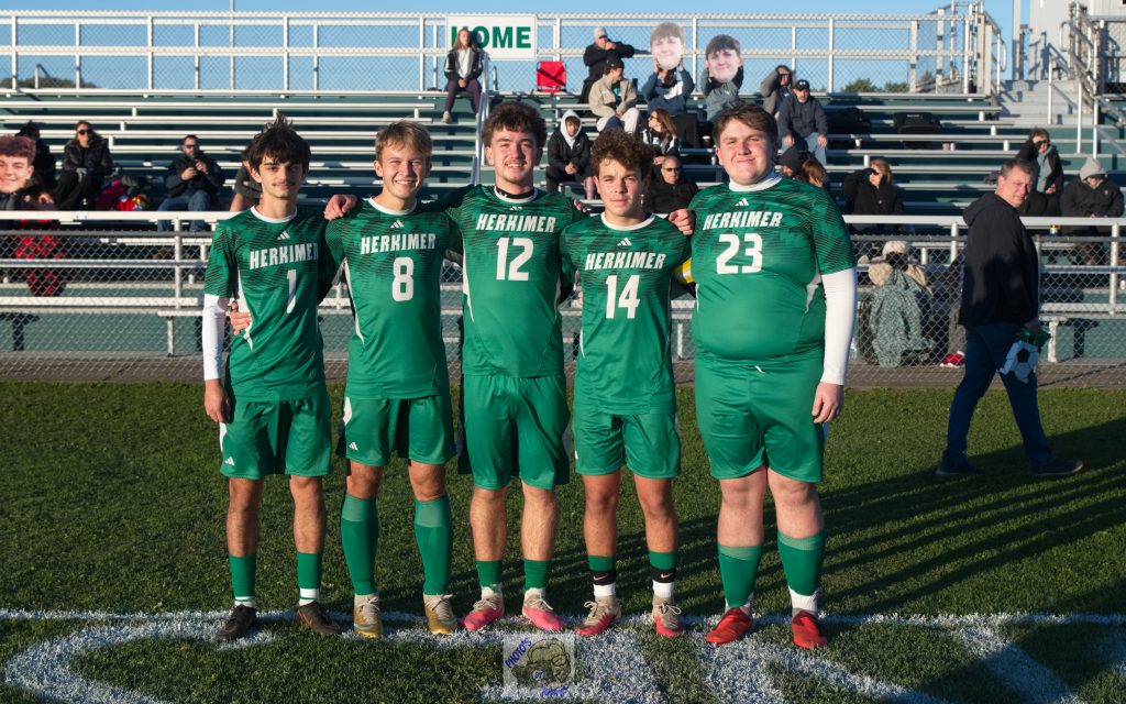 Boys varsity soccer seniors in front of stands