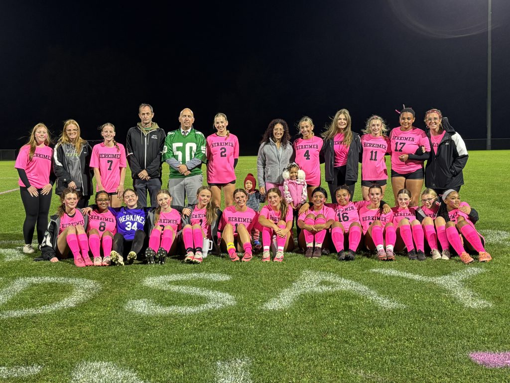 Girls soccer players and teachers on field